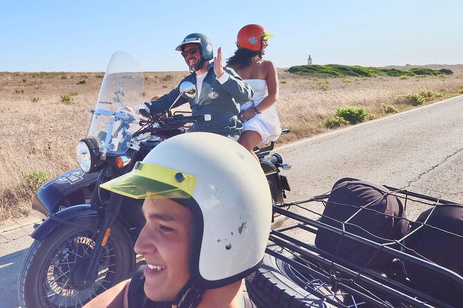 Lisbon - Private Vintage Sidecar Tour to Sesimbra's Coast - Stop 2: Beach time with sand, rocks, and umbrellas nearby